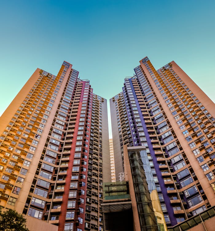 about-img Tall, colorful skyscrapers reaching into the blue sky in Hong Kong, showcasing modern architecture.
